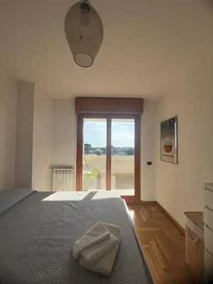 a bedroom with a bed and a large window at Mi Casa Es Tu Casa Roma in Rome