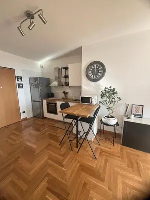 a kitchen and dining room with a table and a clock at Mi Casa Es Tu Casa Roma in Rome