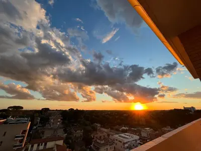 a sunset from the balcony of a building at Mi Casa Es Tu Casa Roma in Rome
