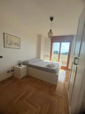 a bedroom with a bed and a wooden floor at Mi Casa Es Tu Casa Roma in Rome
