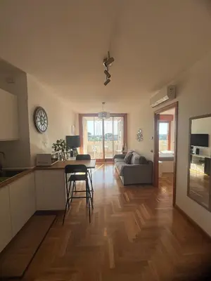 a kitchen and living room with a table and a couch at Mi Casa Es Tu Casa Roma in Rome