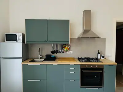 a kitchen with blue cabinets and a white refrigerator at Casa Duci in Rome