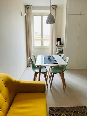 a living room with a yellow couch and a table and chairs at Casa Duci in Rome