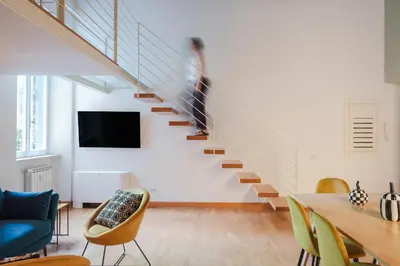 a person walking up a staircase in a living room at Elegant apartment with patio at Piazza Navona in Rome