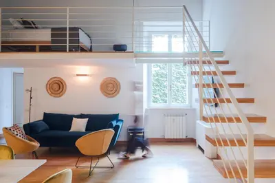 a living room with a blue couch and a staircase at Elegant apartment with patio at Piazza Navona in Rome