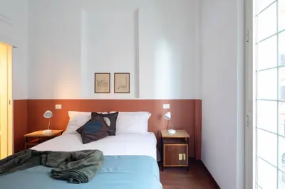 a bedroom with a bed and two tables with lamps at Nuovo appartamento a S. Lorenzo con 3 camere in Rome