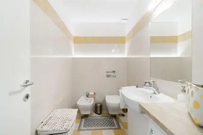 a white bathroom with a toilet and a sink at Brightful Boutique Apartment in the Heart of Trastevere in Rome