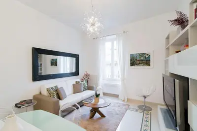 a white living room with a couch and a tv at Brightful Boutique Apartment in the Heart of Trastevere in Rome