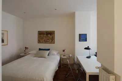 a white bedroom with a bed and a desk at Modern pied a terre near Piazza Navona in Rome