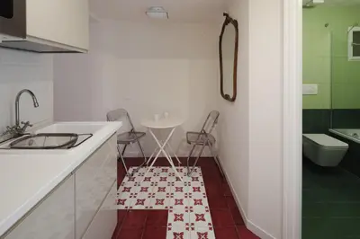 a kitchen with a sink and two chairs and a bathroom at Modern pied a terre near Piazza Navona in Rome