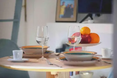 a table with two glasses of wine and a bowl of fruit at Urbana Suite in Rome