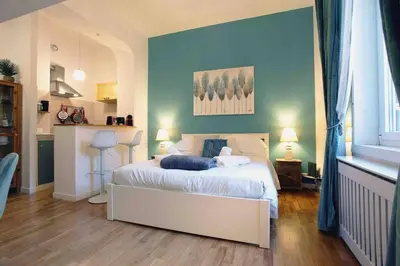 a bedroom with a white bed with a blue wall at Urbana Suite in Rome