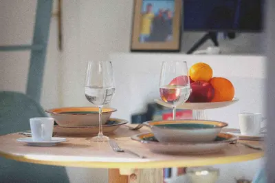 a table with two glasses of wine and a bowl of fruit at Urbana Suite in Rome