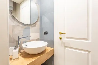 a bathroom with a white bowl sink and a mirror at Daplace - Livia Apartment in Rome