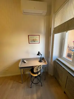 a desk with a lamp on it in a room with a window at San Paolo Inn in Rome