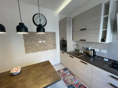 a kitchen with a counter and a clock on the wall at San Paolo Inn in Rome