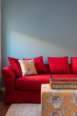 a red couch with red pillows in a living room at Casa Angelica, a Burghesius home in Rome