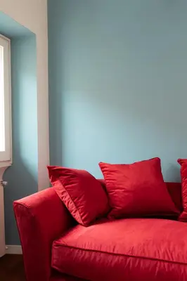 a red couch with red pillows in a room at Casa Angelica, a Burghesius home in Rome