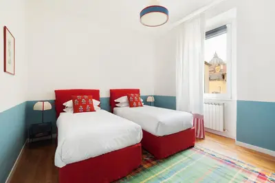 two beds in a room with red and white at Casa Angelica, a Burghesius home in Rome