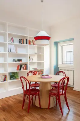 a dining room with a table and red chairs at Casa Angelica, a Burghesius home in Rome