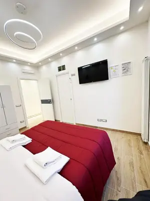 a bedroom with a red bed and a flat screen tv at MUSEUM DAY VATICAN in Rome