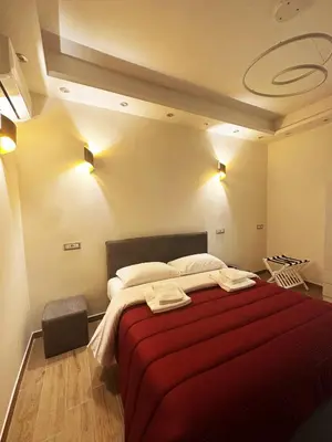 a bedroom with a large bed with red blanket at MUSEUM DAY VATICAN in Rome