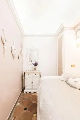 a white bedroom with a bed and a mirror at Piazza Navona - Penthouse in the heart of Rome in Rome