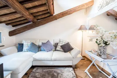 a living room with a white couch and a table at Piazza Navona - Penthouse in the heart of Rome in Rome
