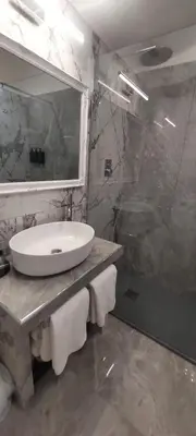 a bathroom with a white sink and a shower at Piazza Navona - Penthouse in the heart of Rome in Rome