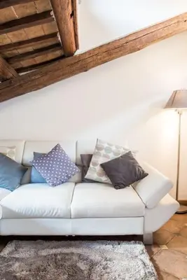 a white couch with pillows on it in a room at Piazza Navona - Penthouse in the heart of Rome in Rome