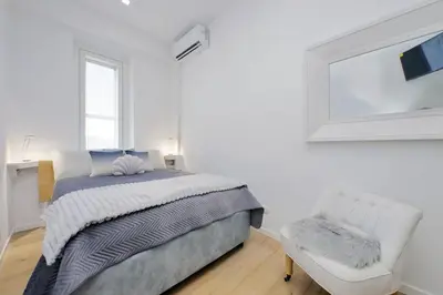 a white bedroom with a bed and a chair at Amazing penthouse in the heart of Rome in Rome