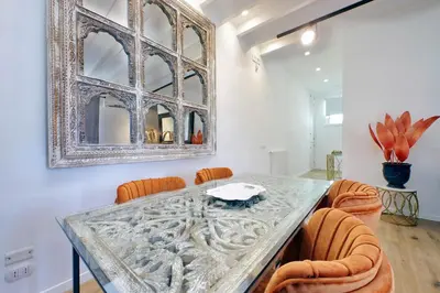 a dining room with a glass table and orange chairs at Amazing penthouse in the heart of Rome in Rome