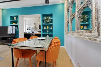a dining room with blue walls and a table with orange chairs at Amazing penthouse in the heart of Rome in Rome