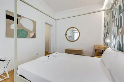 a bedroom with a white bed and a mirror at BMGA l Gracchi Lux Lovely 3Bdr Apartment in Rome