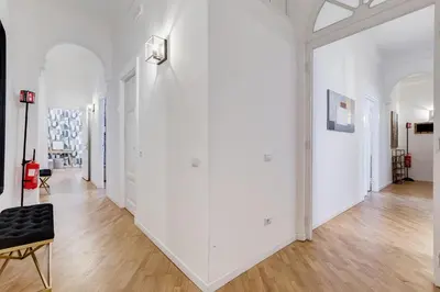 a hallway with white walls and a black chair at BMGA l Gracchi Lux Lovely 3Bdr Apartment in Rome