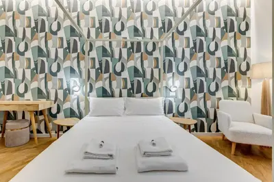 a bedroom with a bed and a wall with a pattern at BMGA l Gracchi Lux Lovely 3Bdr Apartment in Rome
