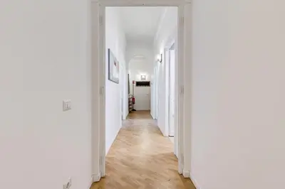 a hallway with white walls and wooden floors at BMGA l Gracchi Lux Lovely 3Bdr Apartment in Rome