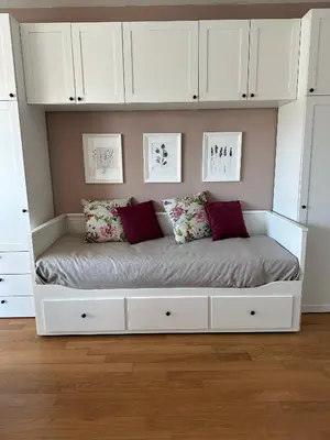 a white bed in a room with white cabinets at Hygge Studio in Rome