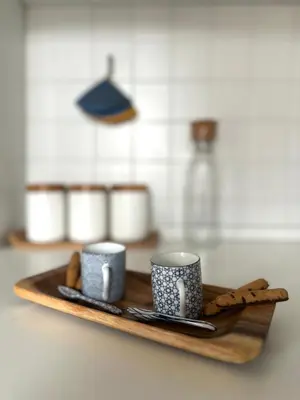 a wooden tray with two cups and cookies on it at Hygge Studio in Rome