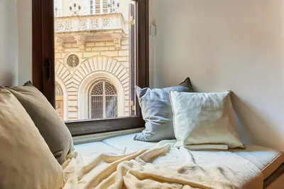a bed with pillows sitting next to a window at iFlat Marvellous home near Via del Corso in Rome