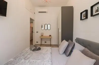 a bedroom with a large white bed and a table at San Pietro - moderno appartamento in Rome