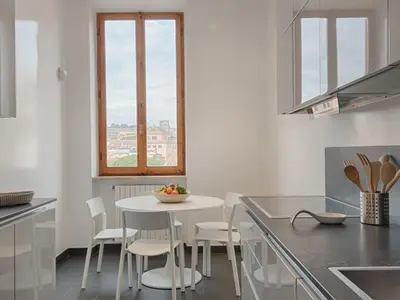a white kitchen with a white table and chairs at Apartment Le Colonne by Interhome in Rome