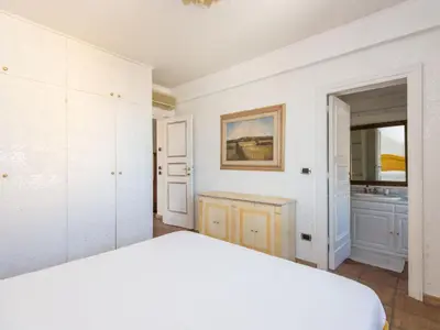 a white bedroom with a bed and a mirror at Apartment Santa Cecilia View by Interhome in Rome