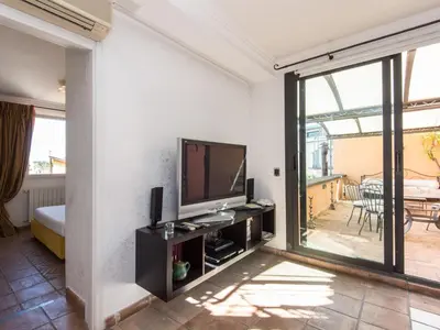 a living room with a television and a balcony at Apartment Santa Cecilia View by Interhome in Rome