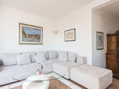 a living room with a white couch and a glass table at Apartment Santa Cecilia View by Interhome in Rome