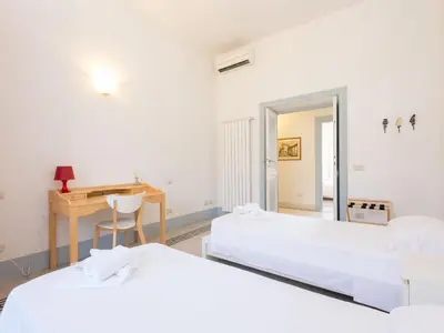 a room with two beds and a desk and a table at Apartment Angelico by Interhome in Rome