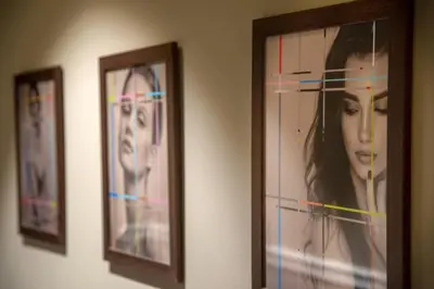 three pictures of a woman are hanging on a wall at Condotti Belvedere in Rome