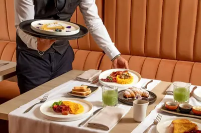 a person holding a tray of food on a table at Condotti Belvedere in Rome