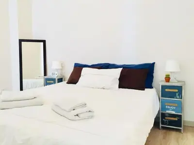 a bedroom with a large white bed with a mirror at Maison de' Trastevere in Rome