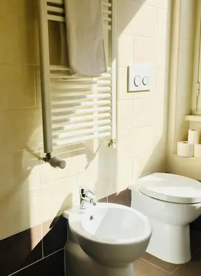 a bathroom with a white toilet and a sink at Maison de' Trastevere in Rome
